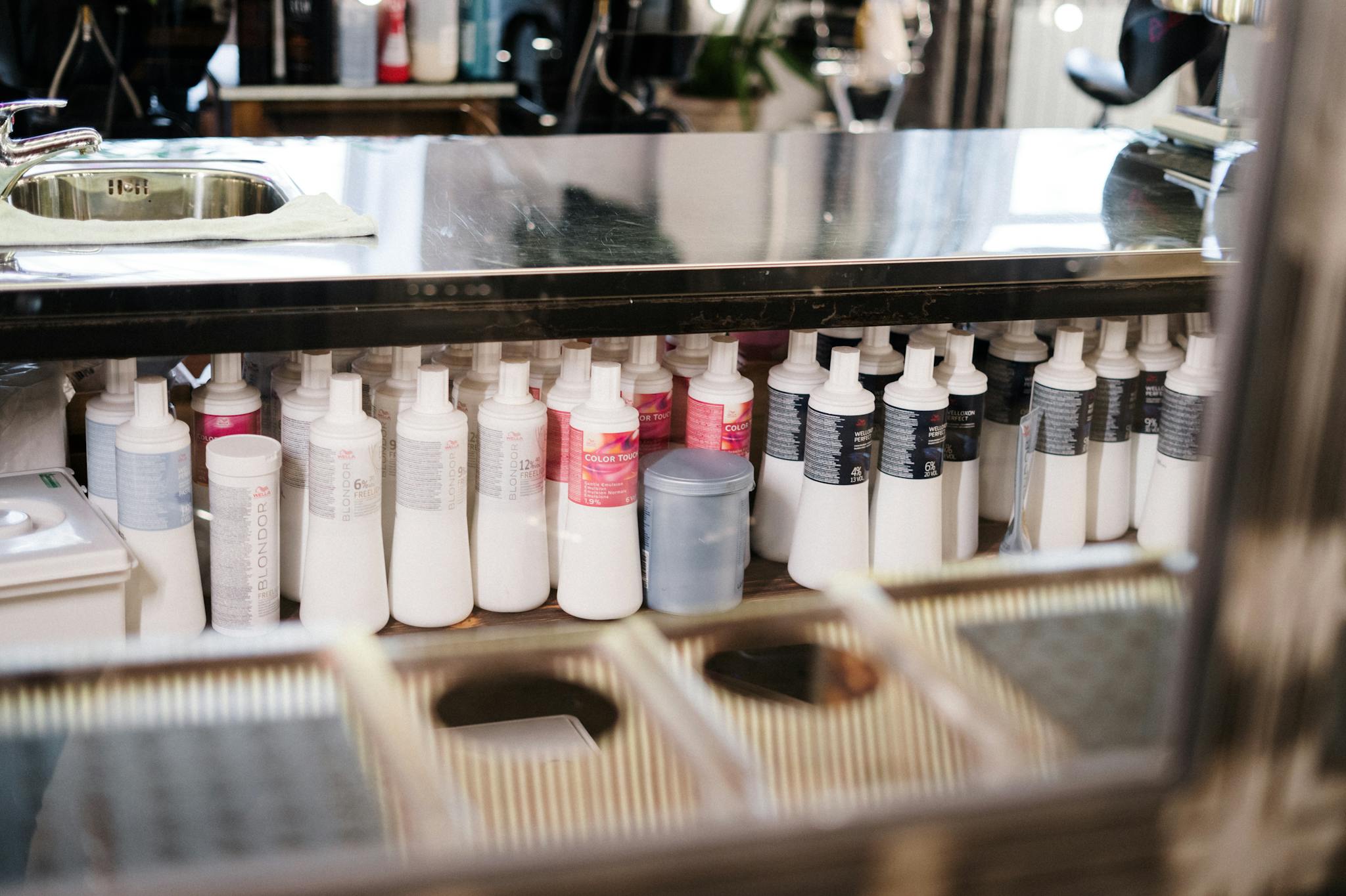 A neat arrangement of hair care products on a salon shelf. Ideal for hairstyling concepts.
