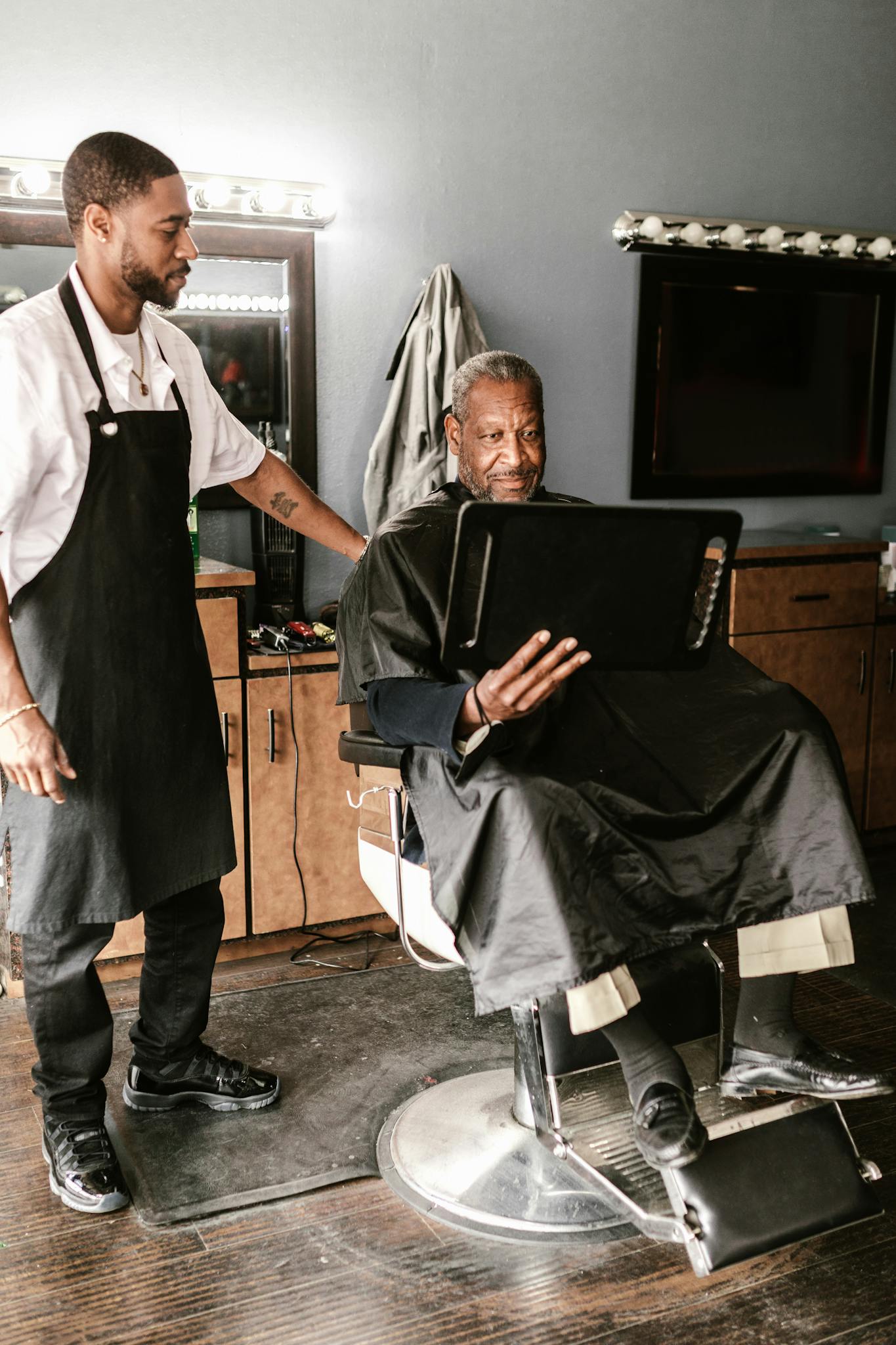 Barber and customer engaging in a haircut session with conversation in a cozy barbershop.
